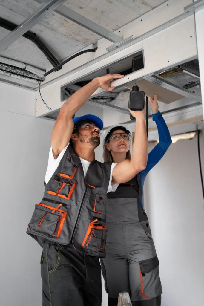 Technicians performing repair services on an air-conditioning unit